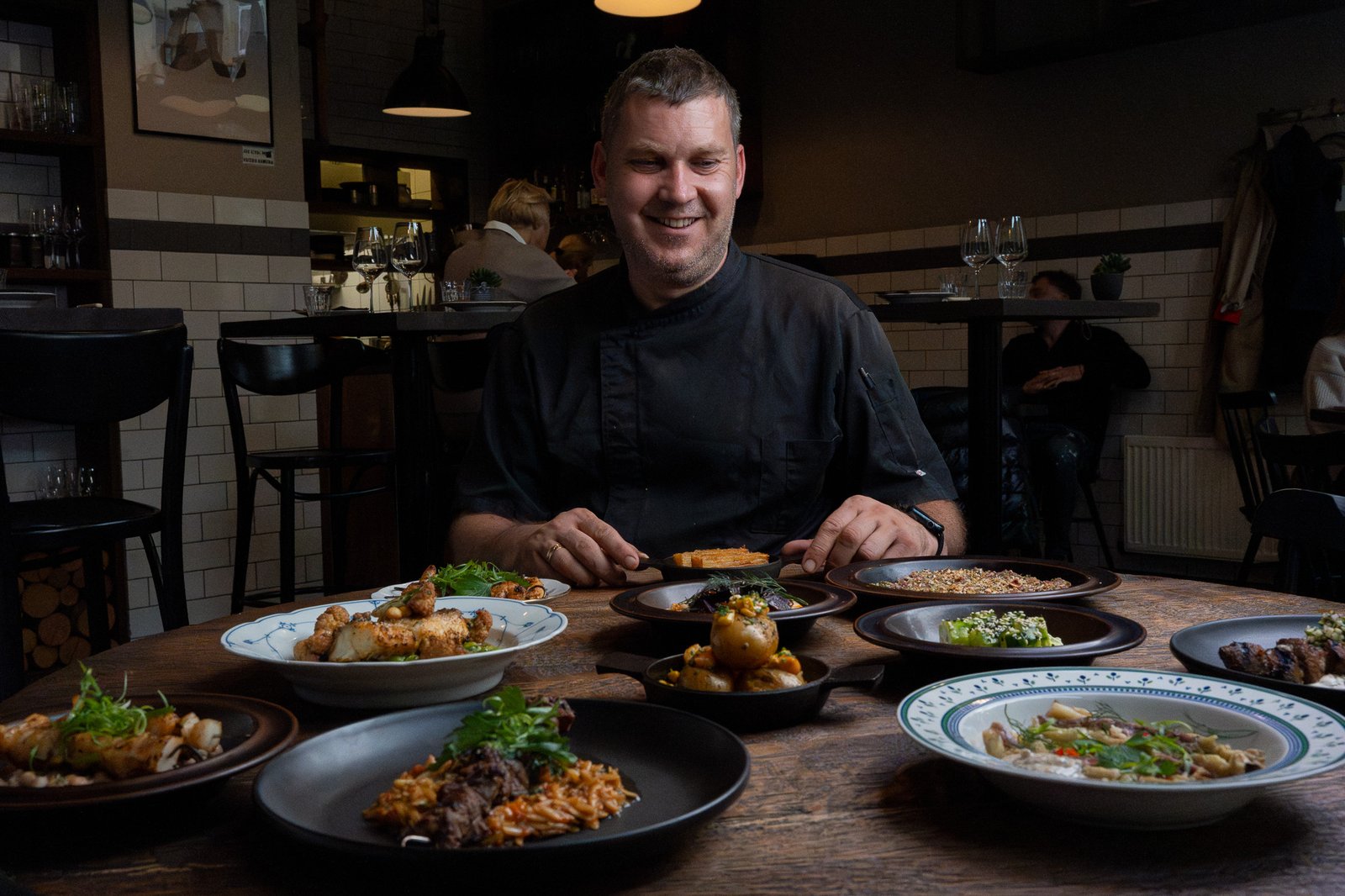 Chef with a table of dishes at MOMO Grill Klaipėda